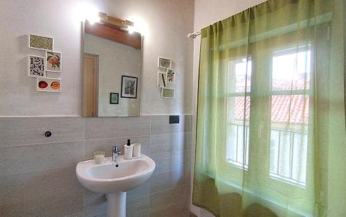 La salle de bains est pourvue d'un lavabo et d'une fenêtre. dans l'établissement [Centro Storico] Casa con Wi-Fi e Parcheggio a 100m, à Saluces