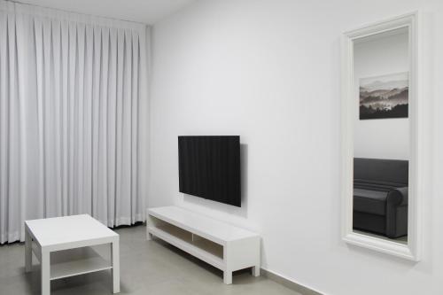 sala de estar blanca con TV y mesa en Luxury Suite Apartment #58 By Hashdera Eilat, en Eilat