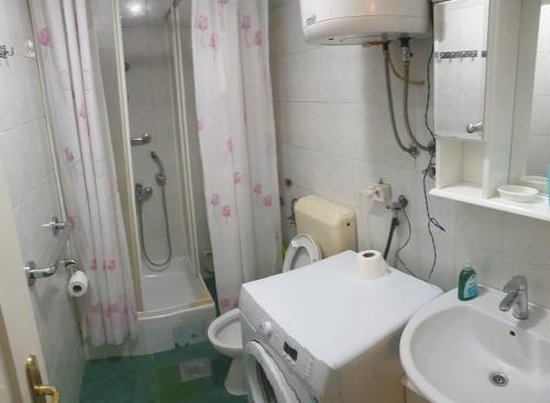 uma casa de banho com um WC, um lavatório e um chuveiro em 2 Bedroom Apartment, Grbavicka em Sarajevo