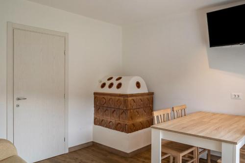 a dining room with a table and a wooden cabinet at Silbernagl sonnig mit Gartenblick in Issengo