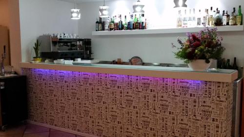 a bar with purple lights on a wall at Hotel L'Ogliera in Pomonte