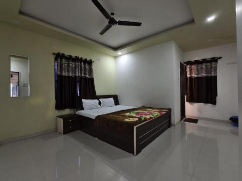 een slaapkamer met een bed en een plafondventilator bij Shayadri Farmhouse in Mahabaleshwar