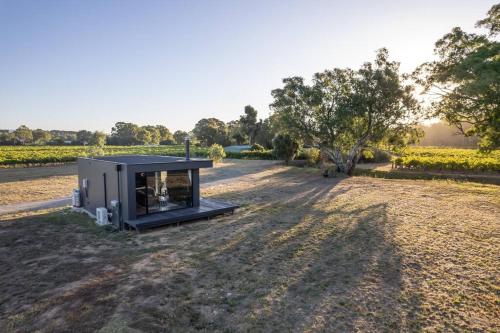 a small building sitting on the side of a field at Luxury Vineyard Cabin Escape in McLaren Flat