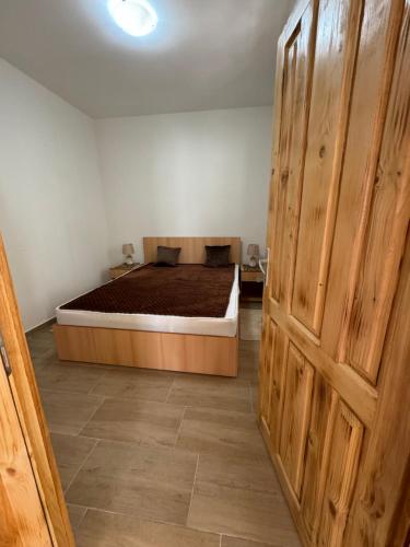ein Schlafzimmer mit einem Bett und einer großen Holztür in der Unterkunft Vikendica Ozren in Sokobanja