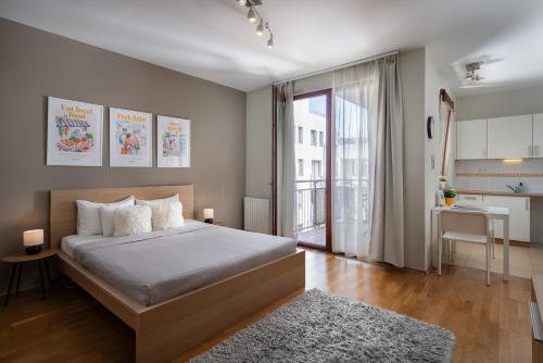 a bedroom with a large bed and a kitchen at Central Passage Apartments by Vagabond in Budapest