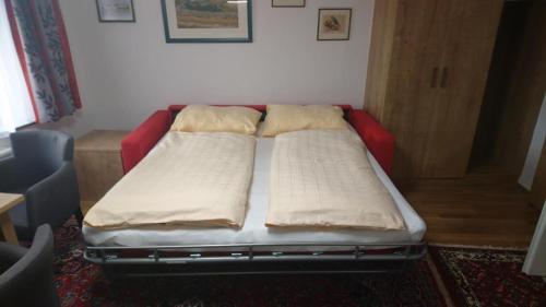 ein Bett mit zwei Kissen auf einem Zimmer in der Unterkunft Appartement 2 Personen Hallein bei Salzburg in Hallein