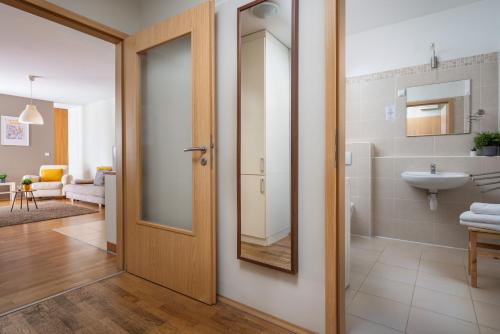 a bathroom with a wooden door and a sink at Central Passage Apartments by Vagabond in Budapest