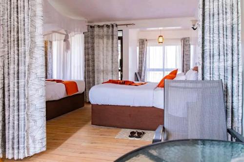 ein Hotelzimmer mit 2 Betten und einem Glastisch in der Unterkunft Naivasha Wonderland Resort in Naivasha