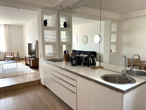 uma cozinha branca com um lavatório e uma sala de estar em Port de Saint-Tropez em Saint-Tropez