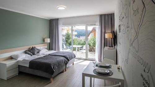 una camera con letto, tavolo e scrivania di Livigno - Czarna Góra Resort by Sun & Snow z nielimitowanym basenem a Sienna