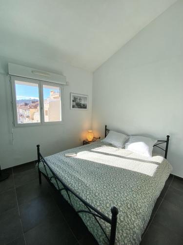 un lit dans une chambre avec une fenêtre dans l'établissement TOBIAS - Appartement Duplex 4 personnes Quartier Riquier Nice, à Nice