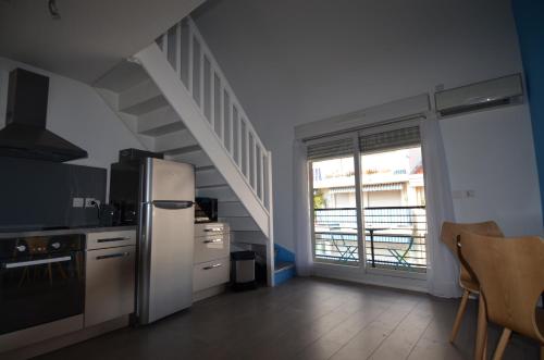 a kitchen with a white refrigerator and a staircase at Appartement Duplex 4 personnes Quartier Riquier Nice in Nice