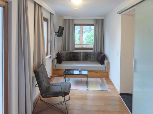 a living room with a couch and a chair at HUBER's Boutiquehotel in Mayrhofen