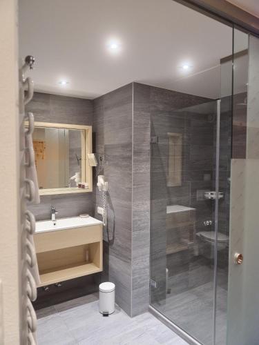 a bathroom with a shower and a sink and a toilet at HUBER's Boutiquehotel in Mayrhofen