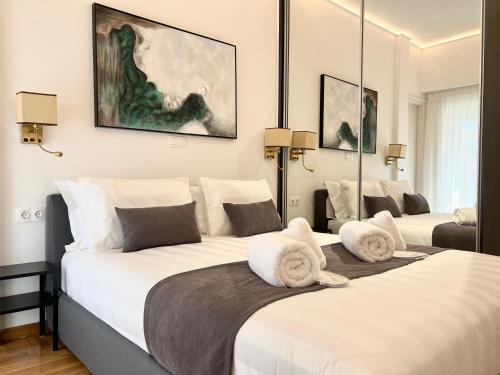 sypialnia z 2 łóżkami i białymi poduszkami w obiekcie Acropolis Golden View Penthouse w Atenach