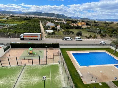una vista aérea de una pista de tenis con piscina en Apartamento frente al mar, en Oliva