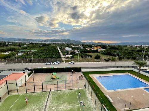 una imagen de una pista de tenis y una piscina en Apartamento frente al mar, en Oliva