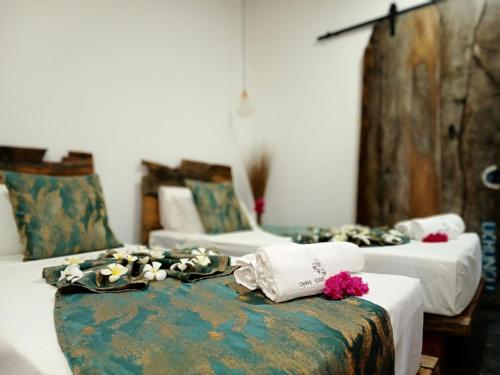 2 Betten in einem Zimmer mit Blumen auf der Couch in der Unterkunft Opera Hotel in Nungwi