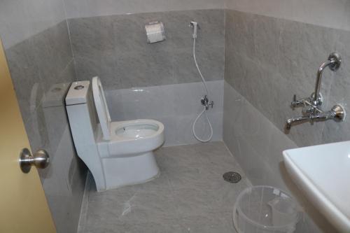 a bathroom with a white toilet and a sink at HOTEL NAMAHA in Shamshabad