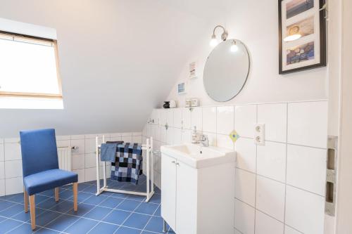 een badkamer met een wastafel en een spiegel bij Ferienwohnung "Tee Tied" 35225 in Hesel