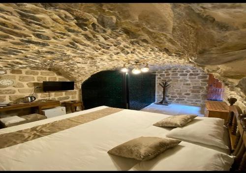 a bedroom with a large bed in a stone wall at Old City Tourism in Mardin