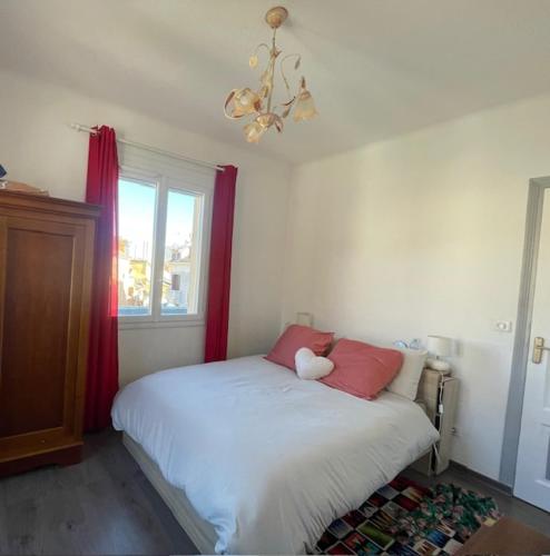 1 dormitorio con 1 cama con cortinas rojas y ventana en Sababou, en Gap