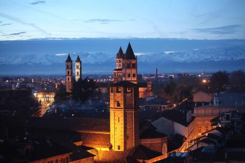a view of a city at night with a clock tower at L'anfiteatro in Vercelli