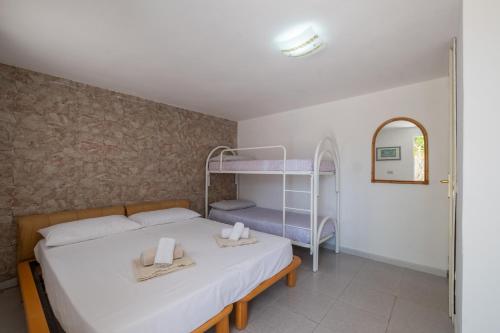 Łóżko lub łóżka piętrowe w pokoju w obiekcie Camera in Villa, 1 minuto da Porto Pino
