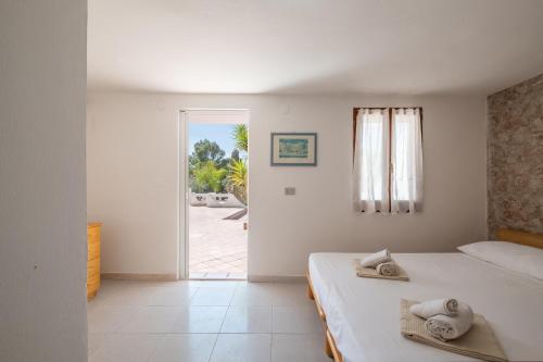 a bedroom with a bed with towels on it at Camera in Villa, 1 minuto da Porto Pino in Porto Pino