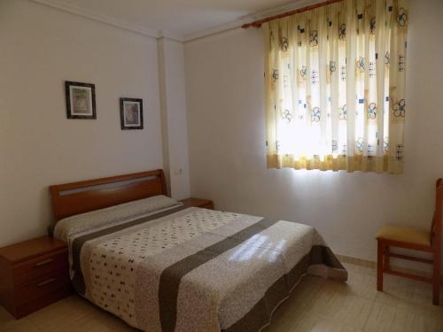 um quarto com uma cama e uma janela com cortinas em Holiday Costa marina 3MED006 em El Borseral