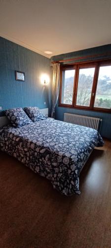 1 dormitorio con 1 cama con colcha azul y 2 ventanas en Maison de la colline de pam, en Cornimont