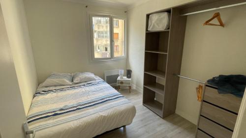 une petite chambre avec un lit et une fenêtre dans l'établissement Proche centre-ville et calme, à Marseille