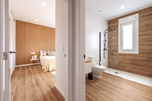 a bedroom with a bed and a bathroom with a shower at Apartamento White Tree by Arca Azahar in O Pedrouzo