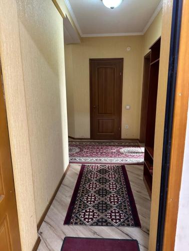 an empty hallway with a door and a rug at guest house djal in Bishkek