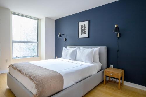 a bedroom with a large bed with a blue wall at Downtown 2BR w WD nr Boston Common BOS-244 in Boston