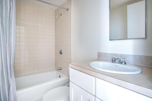 ein Badezimmer mit einem Waschbecken, einem WC und einem Spiegel in der Unterkunft Downtown 2BR w WD nr Boston Common BOS-244 in Boston