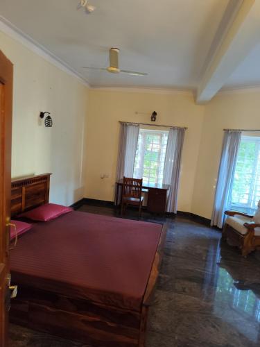 a bedroom with a large bed and two windows at Brindaven in Mysore