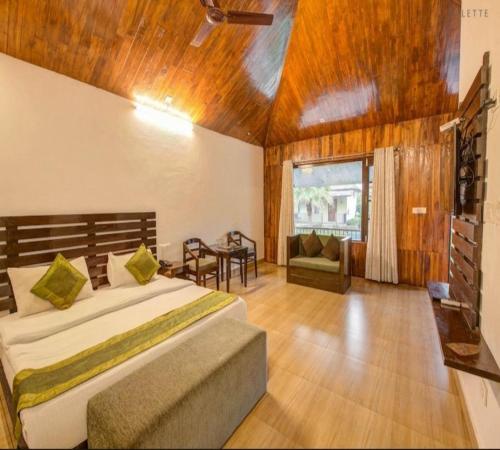 ein Schlafzimmer mit einem Bett und einem Tisch darin in der Unterkunft Corbett Courtyard By The Tigers Pugmark in Belparāo