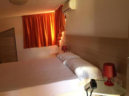a bedroom with a bed and a red window at Hotel Park in Rossano