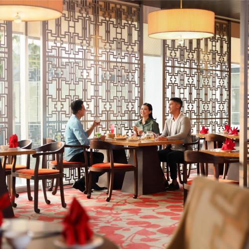 a group of people sitting at a table in a restaurant at Resinda Hotel Karawang in Karawang