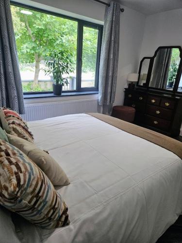 a bedroom with a large white bed with a window at Finner-House in Bundoran