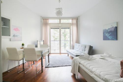 a white living room with a table and chairs at 2ndhomes Kluuvi Apartment 2 in Helsinki