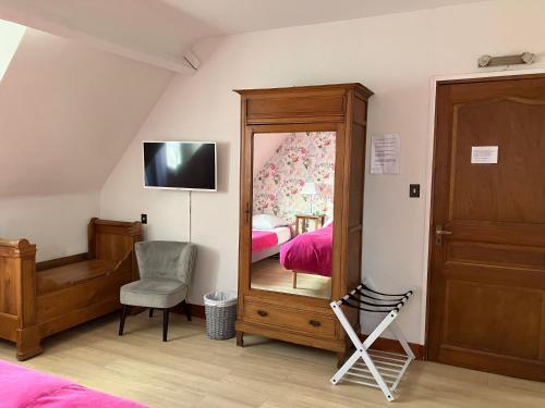 a bedroom with a mirror and a bed and a chair at La Noisetiere in Noyers-sur-Cher