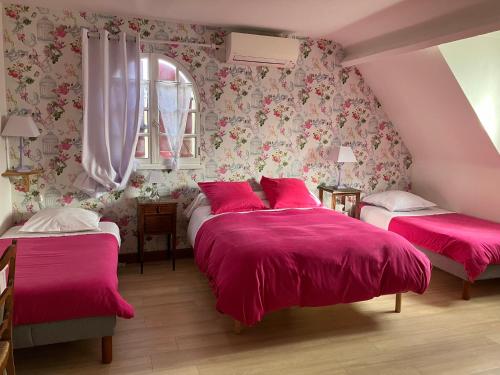 Duas camas num quarto com cobertores cor-de-rosa e flores em La Noisetiere em Noyers-sur-Cher