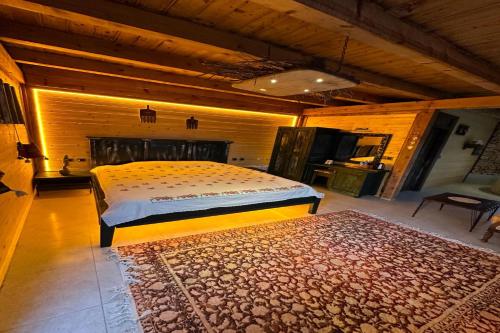 a bedroom with a bed and a rug on the floor at Aşk-ı Nare Cave Hotel in Nevsehir