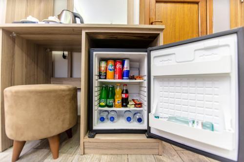 an open refrigerator with drinks in it next to a chair at Gul Otel in Istanbul