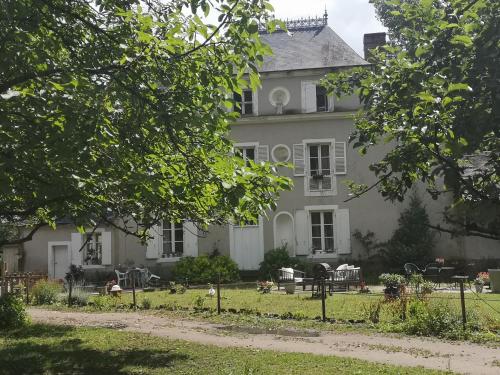 a large white house with a lawn in front of it at Le petit plessis in Ruaudin