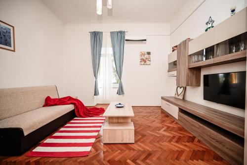 a living room with a couch and a television at Seafront Apartment Ičići in Ičići