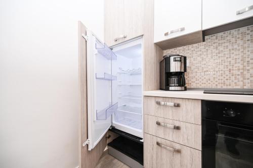 a kitchen with an open refrigerator with a coffee maker at Seafront Apartment Ičići in Ičići