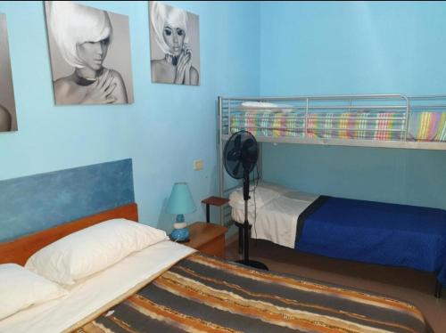 テルモリにあるBed and breackfast Nonna Luciaのベッドルーム1室(ベッド2台付)が備わります。壁に2枚の写真が飾られています。